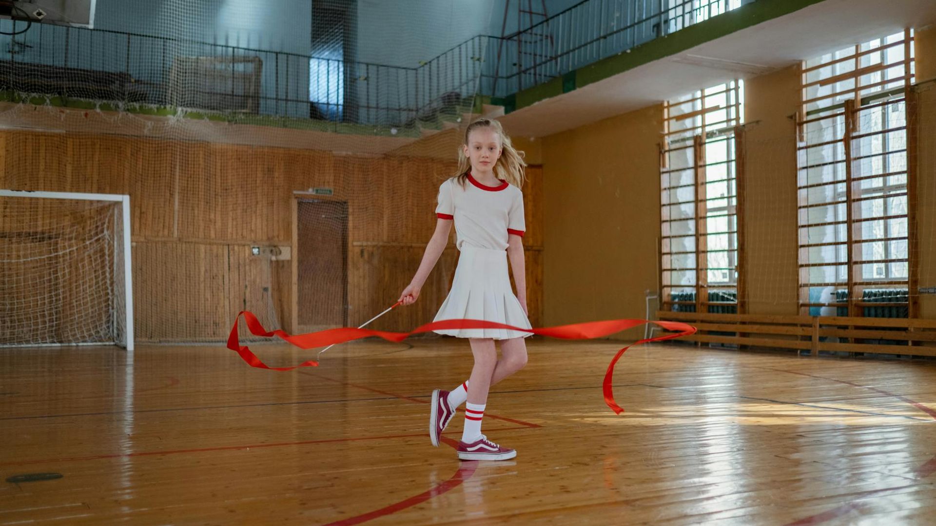 Active person doing rhythmic movement in a dark gym environment.