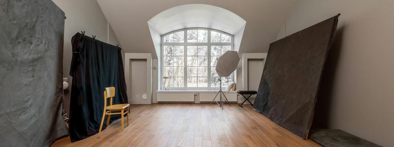 Wide shot of an empty exercise studio with wooden floor.